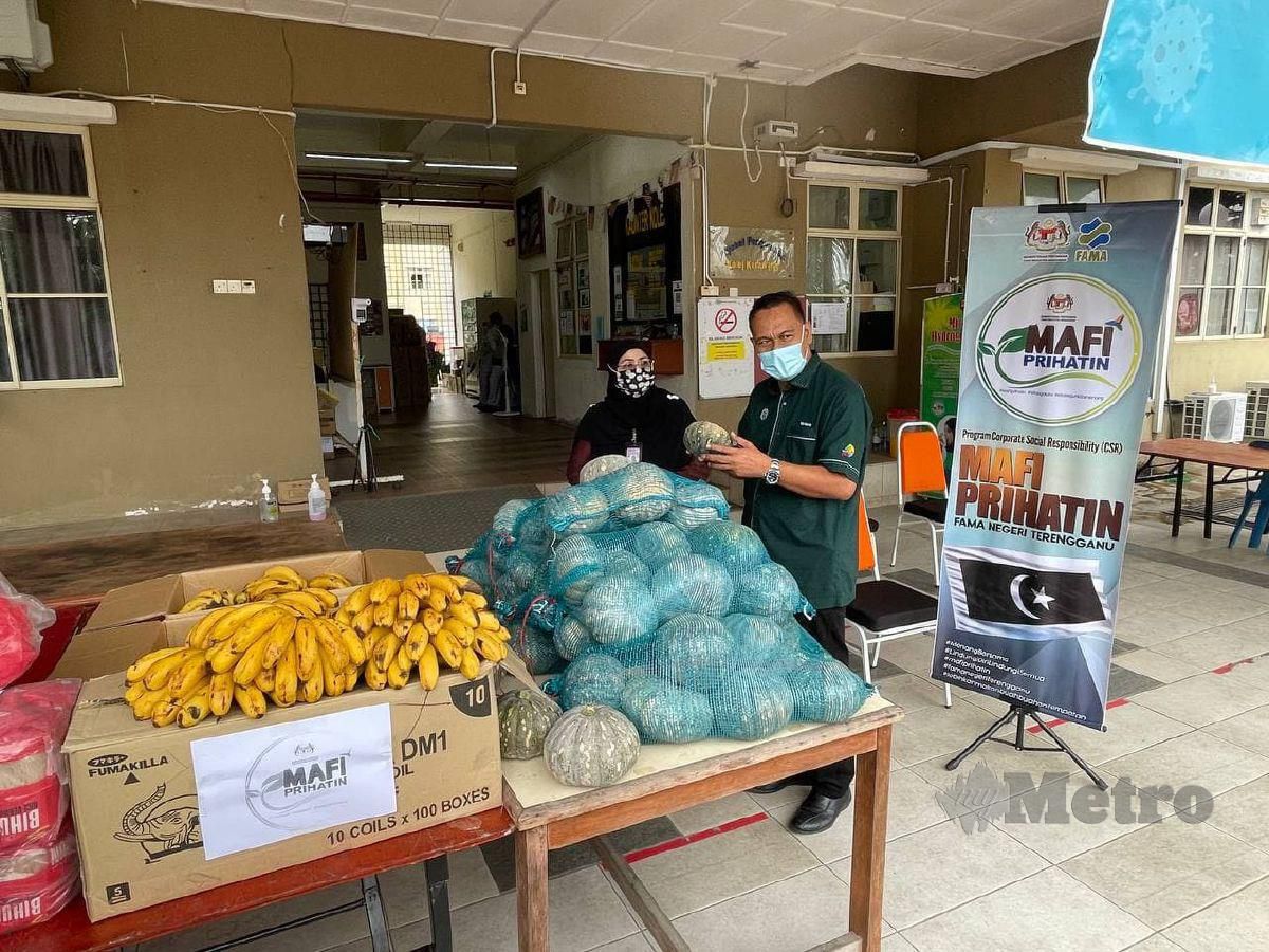 CHE Ghani menyerahkan sumbangan buah-buahan dan sayuran kepada Dr Sharifah Azizah di PKRC UiTM Chendering. FOTO Ahmad Rabiul Zulkifli
