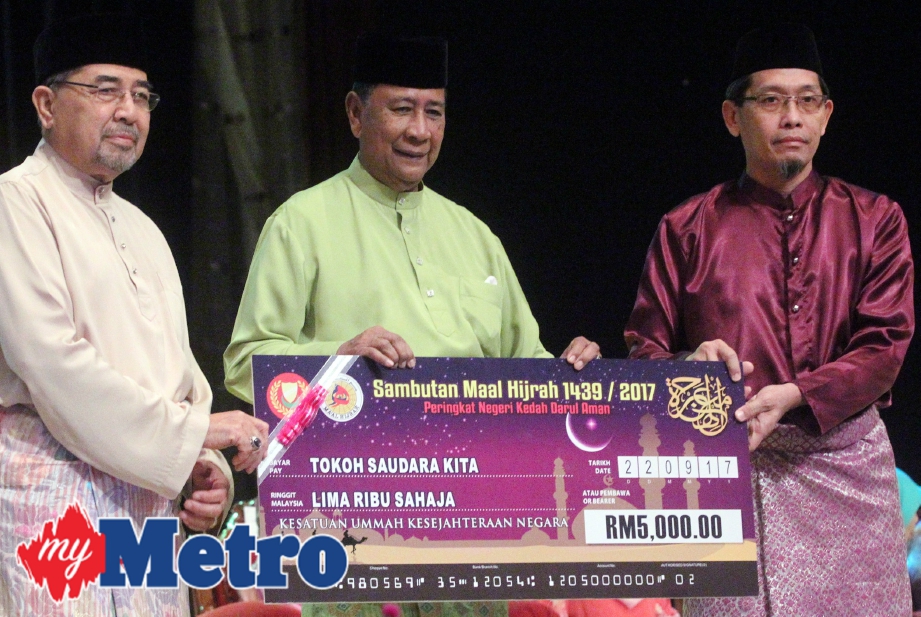 Tuanku Sallehuddin Sultan Badlishah menyampaikan replika cek kepada Umar Lai (kanan) sambil diperhatikan Menteri Besar Kedah, Datuk Seri Ahmad Bashah Md Hanipah. FOTO Amran Hamid 