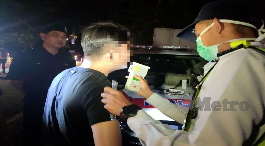 POLIS melakukan ujian pernafasan mengesan kandungan alkohol ke atas pemandu berusia 36 tahun. FOTO Zuliaty Zulkiffli.