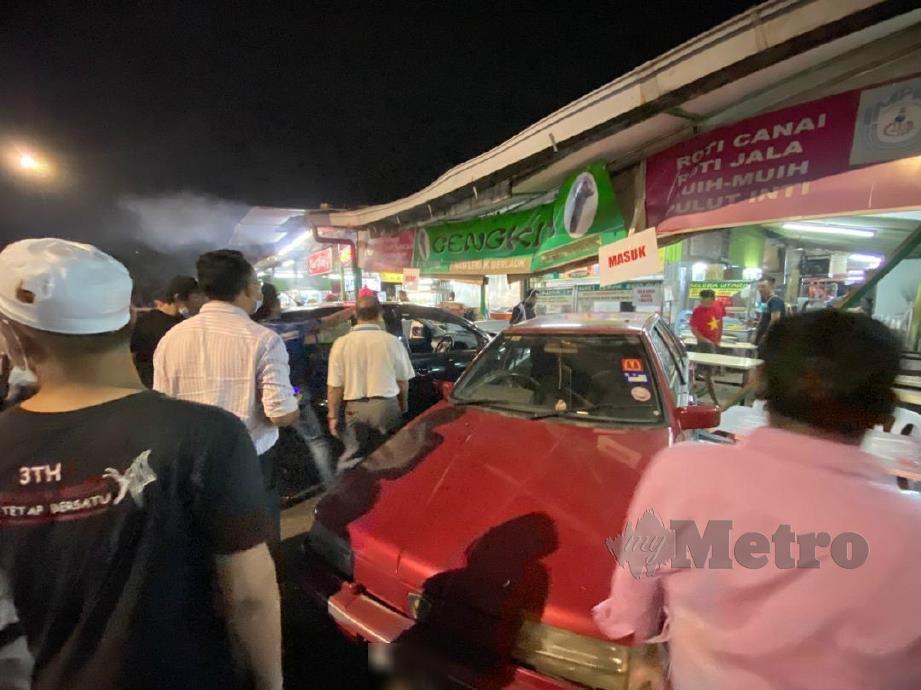 ORANG ramai mengerumuni kedai makan selepas dirempuh Perodua Myvi yang dipandu lelaki mabuk. FOTO  Ihsan Nik Norizan