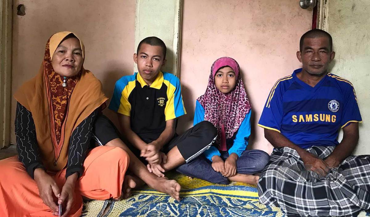MOHD Nasir (kanan) yang diserang angin ahmar bersama isterinya, Rosilawati (kiri) dan dua anak istimewa mereka, Muhammad Luqman (dua kiri) dan Nur Balqis Azzahara ketika ditemui di rumahnya di Kampung Paloh Rawa, Machang. FOTO Hazira Ahmad Zaidi
