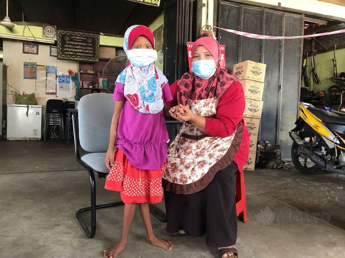 ASMIZA bersama anaknya, Nurhanis yang menderita penyakit buah pinggang kronik serta pelbagai komplikasi masalah saraf, tekanan darah tinggi, dan sawan.  FOTO Hazira Ahmad Zaidi