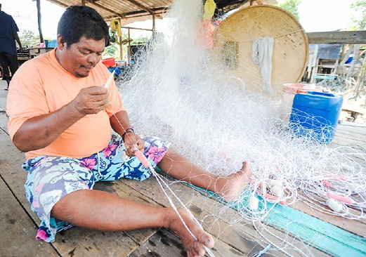 HASAN Puteh, 49, sedang menyiapkan pukat untuk menangkap ikan .