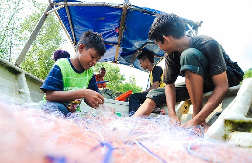 ANAK-anak Orang Asli sedang membantu bapa mereka menangkap ikan.