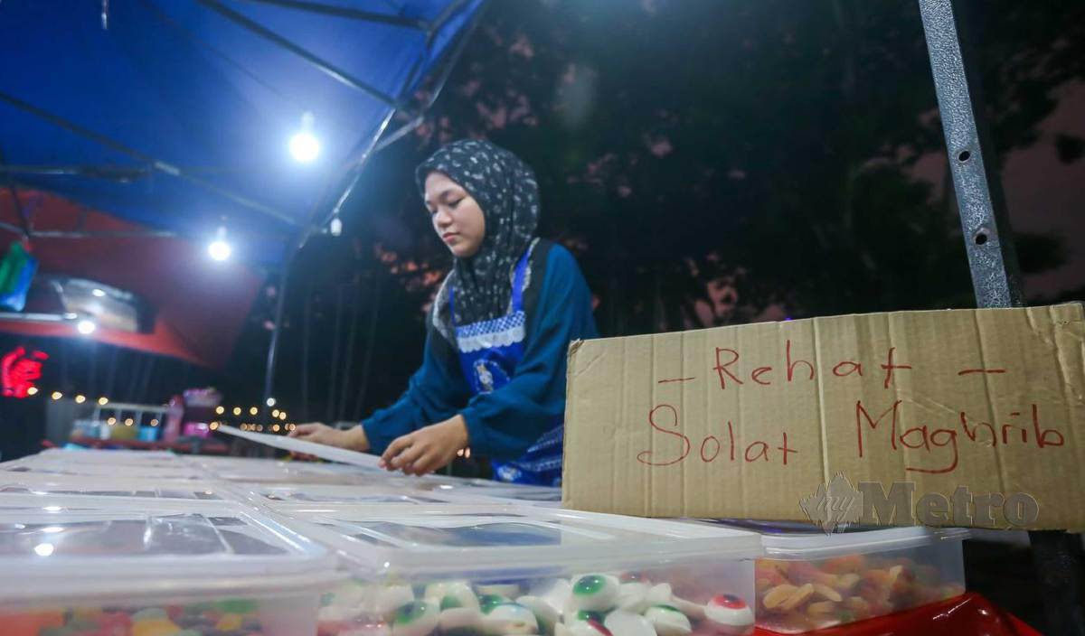 NUR Hidayah mempamerkan tulisan “Rehat Solat Maghrib” sebagai tanda mematuhi Arahan memberhentikan seketika operasi perniagaan pasar malam pada waktu solat Maghrib di seluruh Kedah. FOTO Wan Nabil Nasir