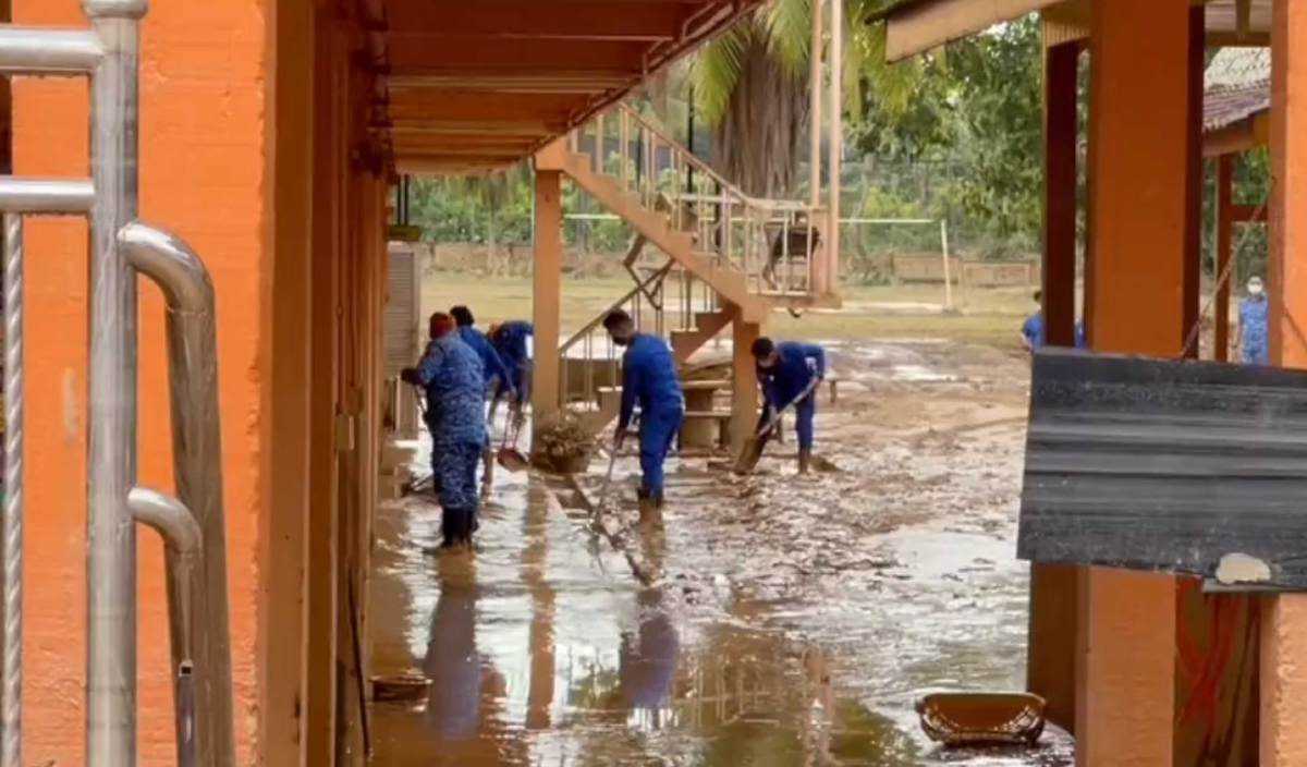 PASUKAN APM dan sukarelawan giat melakukan kerja-kerja pembersihan pasca banjir di SMA Mahmudiah, Hulu Terengganu. FOTO BERNAMA