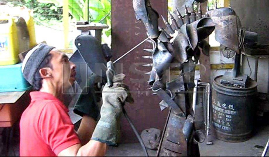 RAJA Shahriman  ketika melakukan kerja kimpalan  bagi menghasilkan arca besi. FOTO NSTP