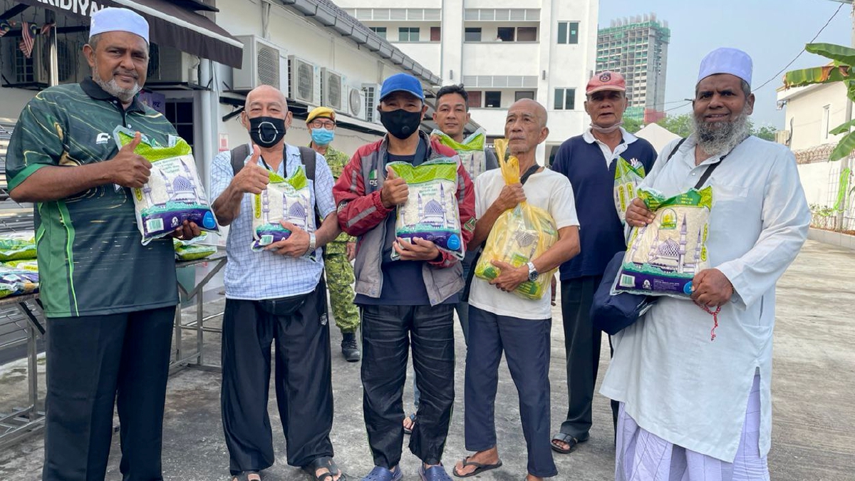 JAWAHAR Ali (kiri) bersama penerima terawal beras percuma di Madrasathul Faridiyah di ibu negara. FOTO Ihsan pembaca.