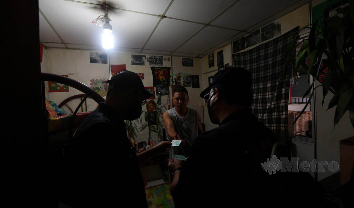 MUHAMAD Fauzi (kanan) bersama pegawainya menyoal siasat warga asing di bilik penginapan pada Operasi Task Force Penguatkuasaan Akta 446 Jabatan Tenaga Kerja Negeri Perak di Pusat Pengumpulan Sayur-Sayuran, Blue Valley. FOTO Sharul Hafiz Zam