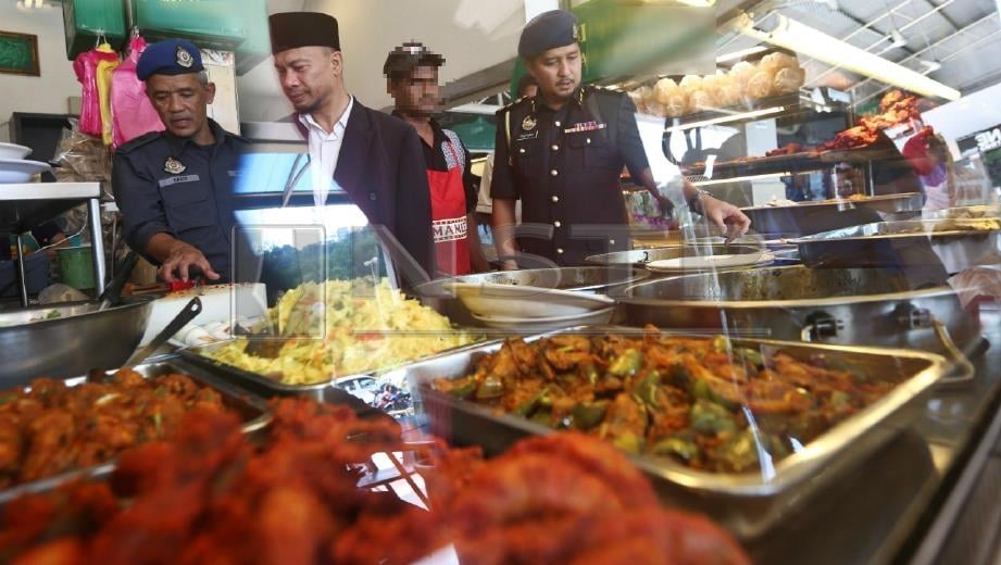 ZULFAMY (kanan) bersama pegawai JHEAT dan Jabatan Kesihatan Negeri melakukan pemeriksaan ke atas restoran yang tidak memiliki Sijil Pengesahan Halal Malaysia (SPHM) di Kuala Terengganu, hari ini. FOTO Ghazali Kori.