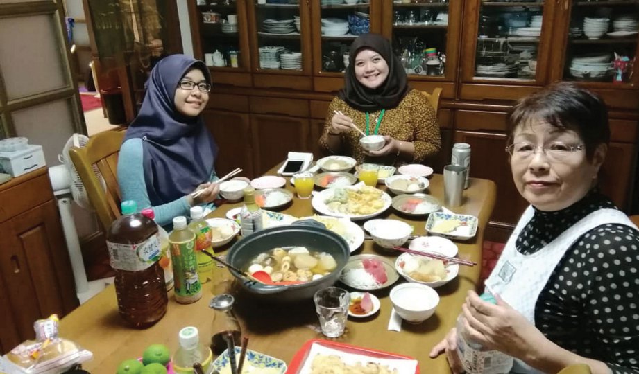 AISHA Rosheila (kiri) bersama rakan dan ibu angkat menikmati makan malam.