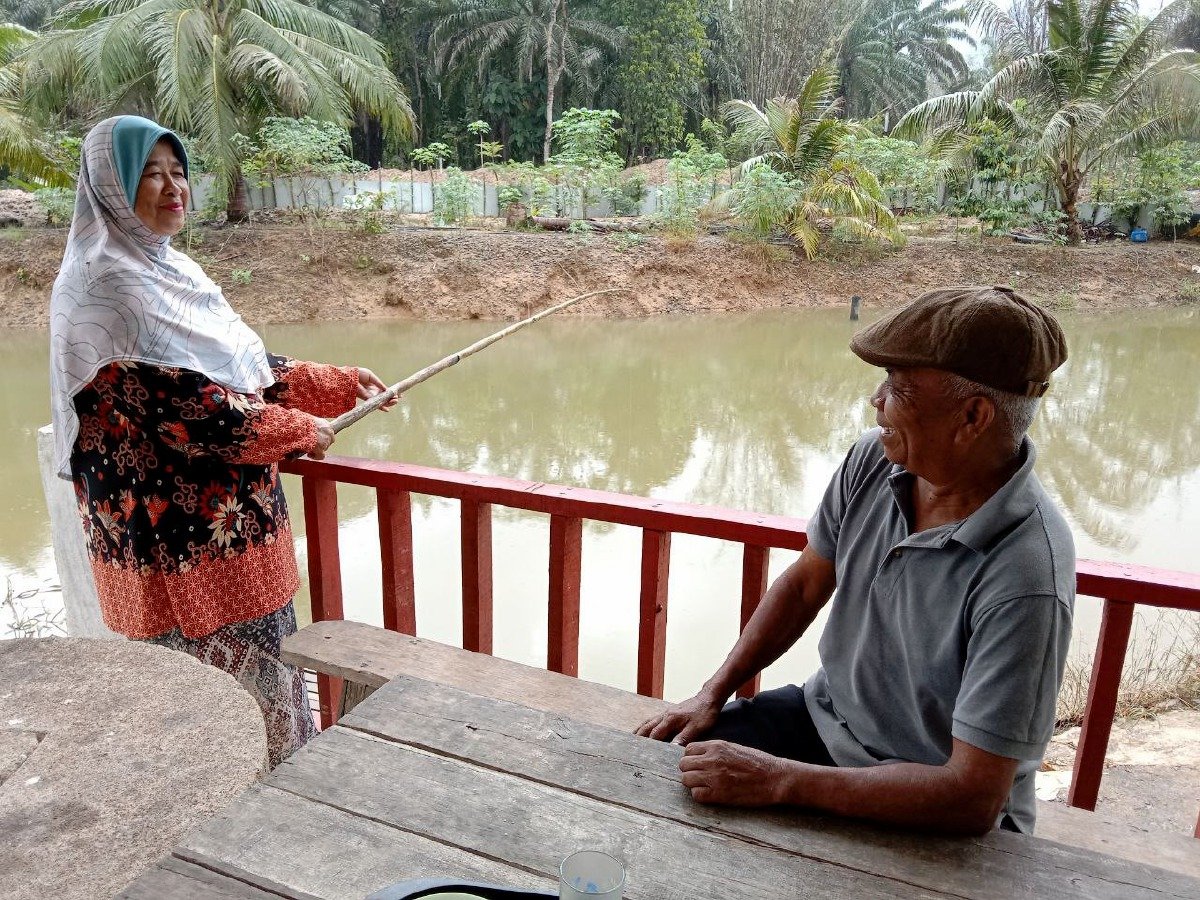 KHATIJAH mengisi masa terluang dengan aktiviti memancing dengan ditemani suaminya, Mamat.