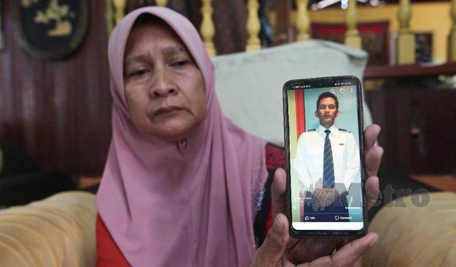 ZALEHA menunjukkan gambar anaknya, Ahmad Farid yang maut dipercayai akibat dipukul dalam kejadian di Kampung Bukit Gasing, Marang. FOTO Ghazali Kori