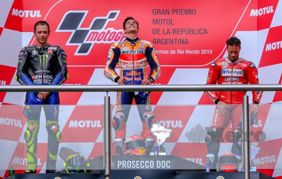 REAKSI Marquez (tengah) di podium selepas menang GP Argentina diapit Rossi (kiri) dan Dovizioso. — FOTO Reuters