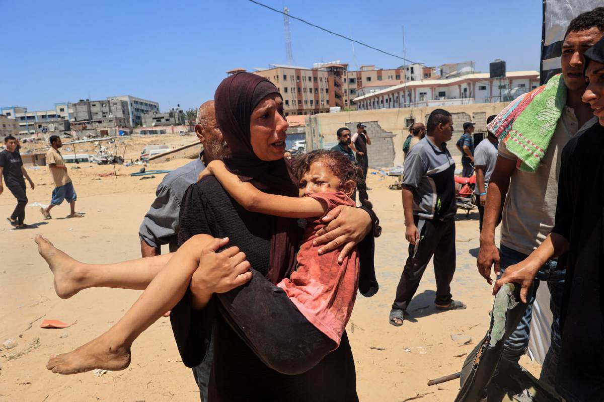 SEORANG wanita Palestin membawa kanak-kanak yang cedera ke Hospital Nasser di Khan Yunis selepas serangan udara di kem Al-Mawasi. FOTO AFP