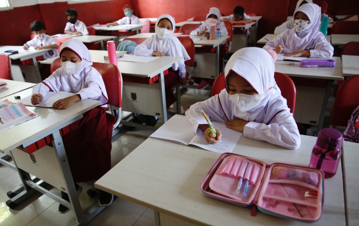 MURID memakai pelitup muka ketika mengikuti pembelajaran di sebuah sekolah di Depok. FOTO EPA 