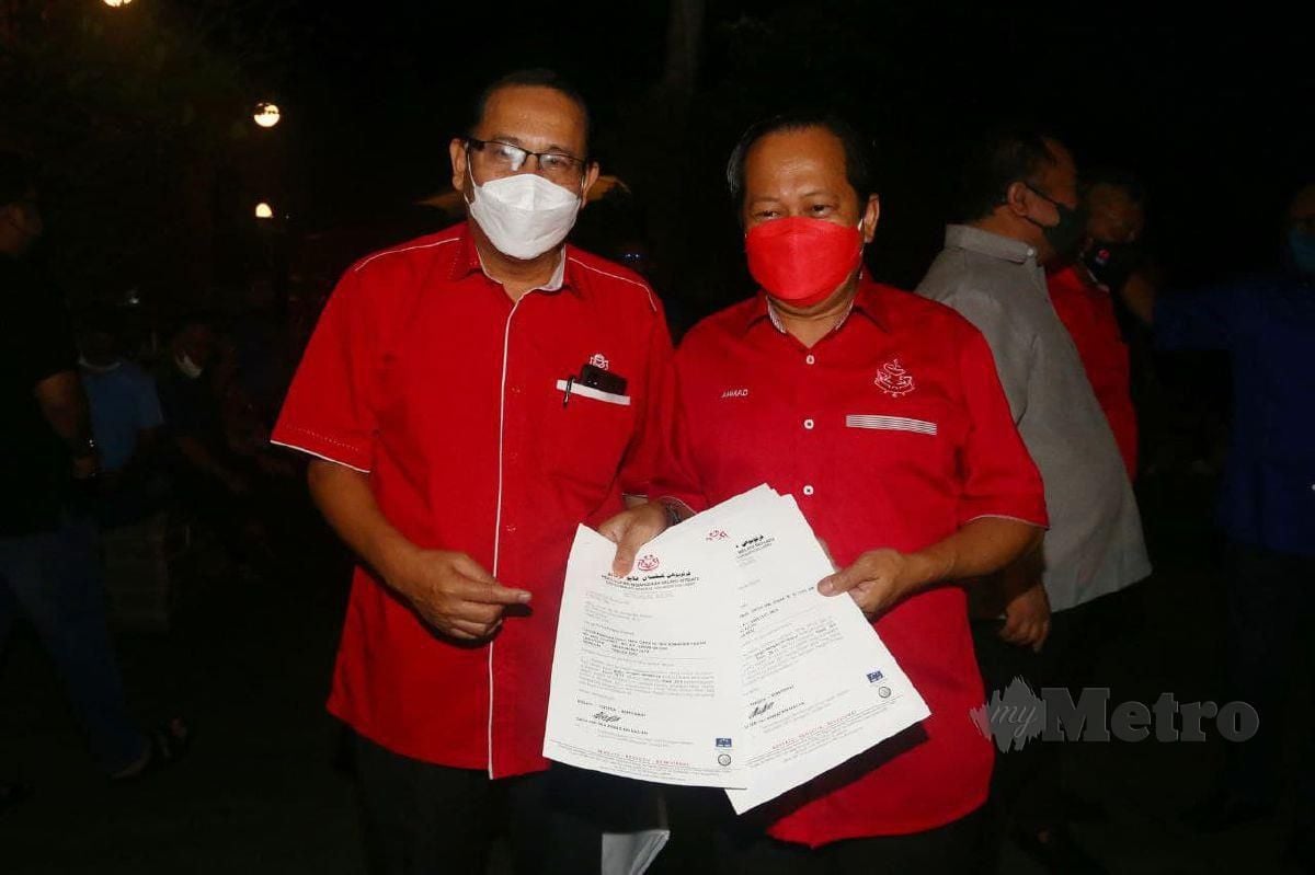 AHMAD (kanan) menunjukkan surat pelucutan keahlian Umno terhadap Idris dan Nor Azman ketika sidang media di Masjid Tanah, Melaka, malam tadi. FOTO SYAFEEQ AHMAD