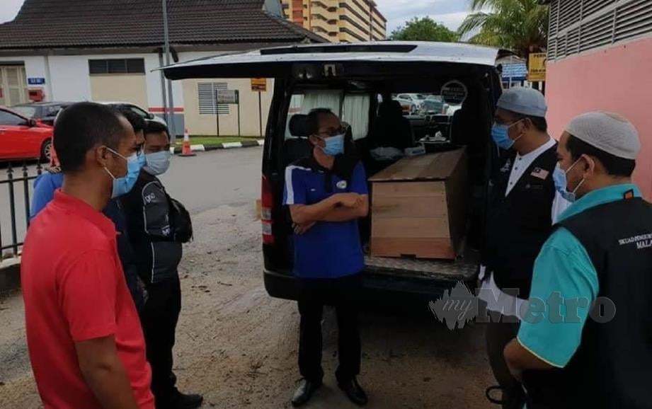 SKUAD Pengurusan Jenazah Malaysia berbincang sebelum menguruskan pengebumian jenazah pesakit Covid-19 di Tanah Perkuburan Islam Setali, Kuantan, Pahang, hari ini. FOTO ihsan Skuad Pengurusan Jenazah Malaysia.