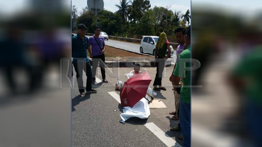 Mayat Mohd Khairil ditutup dengan kain putih selepas motosikalnya bertembung dengan Perodua Myvi. FOTO Ihsan Pembaca