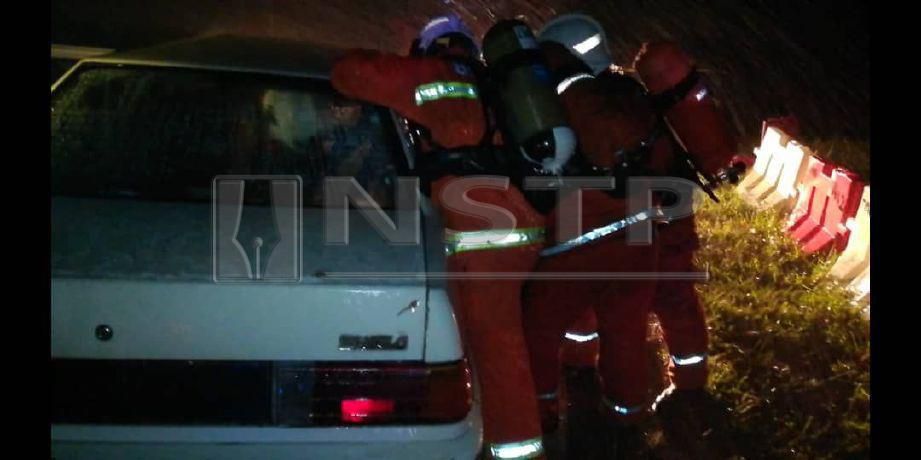 PASUKAN Bomba dan Penyelamat Perak sedang mengeluarkan mangsa daripada kereta terbabit kemalangan. -Foto Ihsan Bomba. 