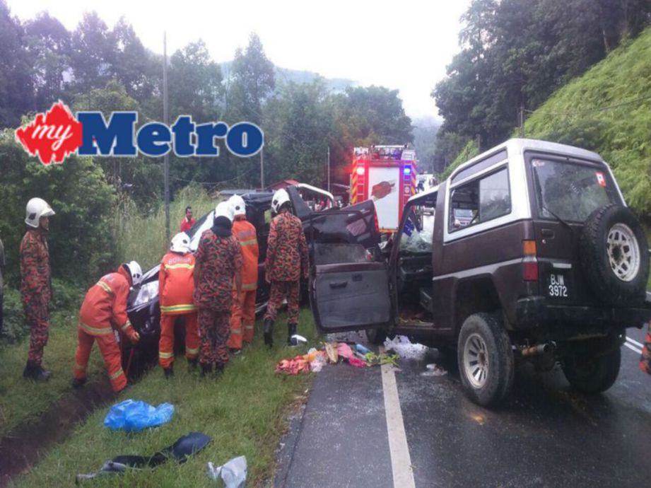 Anggota bomba memeriksa kenderaan terbabit dalam kemalangan di Kampung Sungai Sam, Jalan Kuala Krai-Gua Musang. FOTO Ihsan bomba