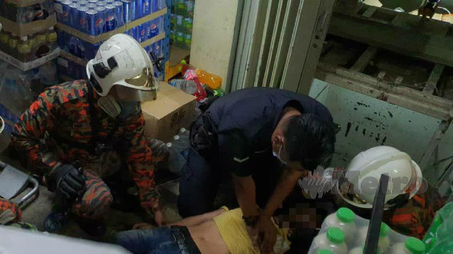 POLIS dan bomba cuba memberi bantuan kepada mangsa yang tersepit di lif pasar raya di Kingfisher, Likas di Kota Kinabalu. FOTO Juwan Riduan