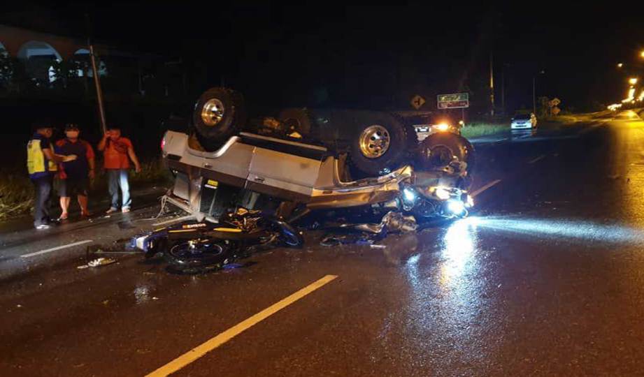 KENDERAAN kenderaan utiliti sukan (SUV) yang terbalik dan melintang selepas terbabit kemalangan yang menyebabkan penunggang motosikal maut di Kilometer 14 , Jalan Serian-Kuching. FOTO Ihsan PDRM