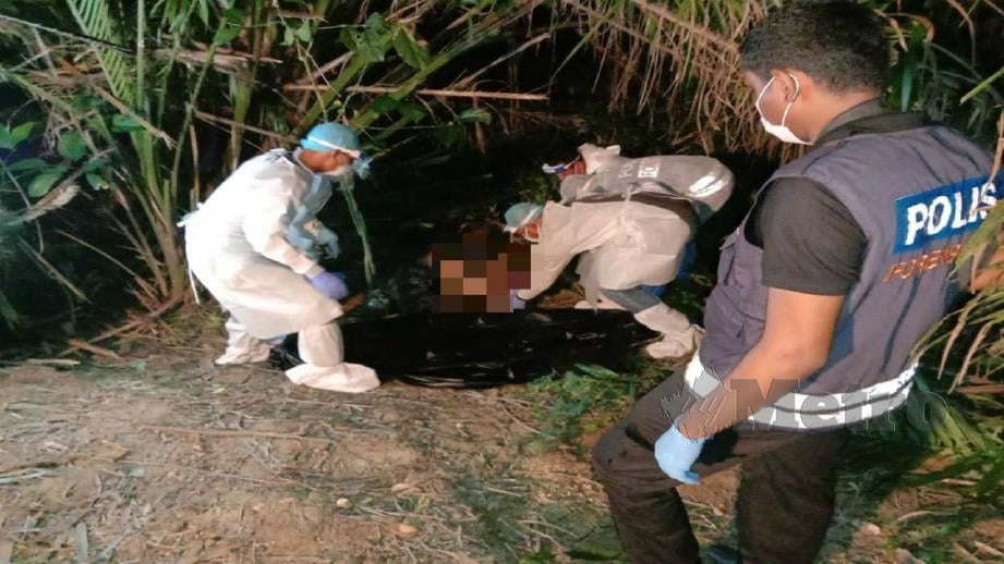 Polis memeriksa mayat wanita yang ditemui dalam ladang kelapa sawit di Jalan Bidor-Sungkai dekat Bidor, semalam. Foto Ihsan PDRM