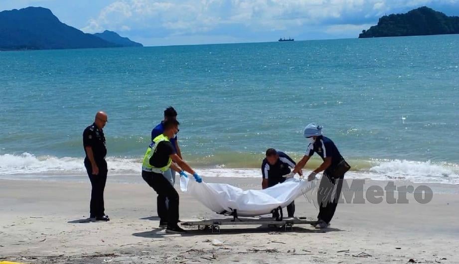 Anggota polis mengangkat mayat reput yang ditemui di tepi Pantai Imigresen Tanjung Rhu. FOTO ihsan pembaca