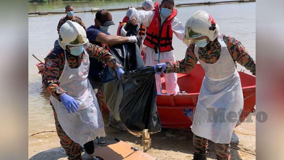 ANGGOTA bomba mengangkat mayat reput yang ditemui di Sungai Perak. FOTO ihsan bomba  