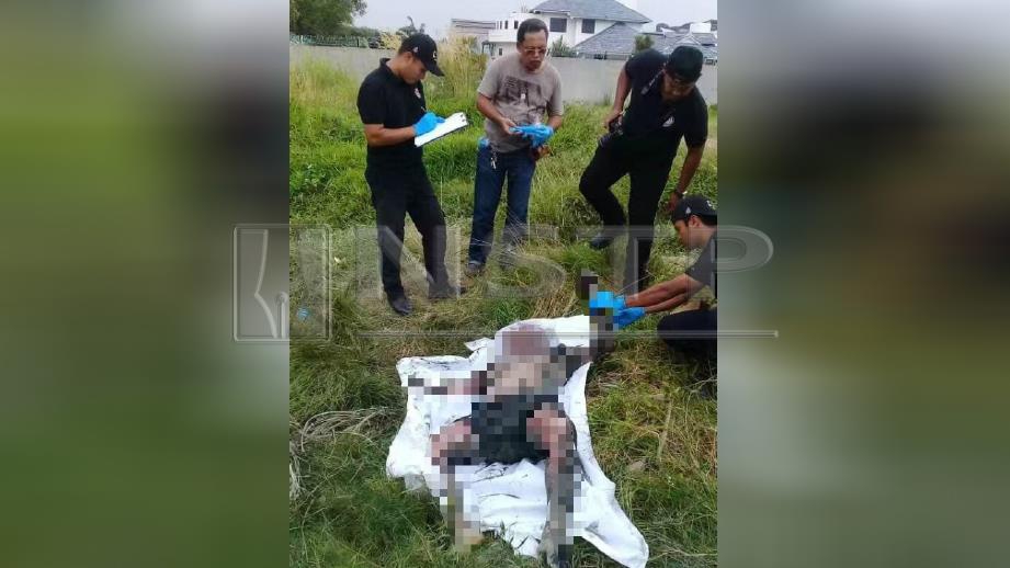 ANGGOTA polis memeriksa mayat lelaki dipercayai warga asing yang ditemui di tepi sungai Perai, Seberang Jaya, petang semalam. FOTO ihsan polis. 