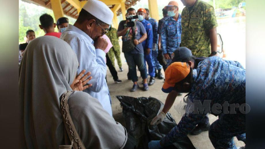 AHLI keluarga Allahyarham Ahmad Syafiq tidak dapat menahan sebak sebaik mayat tiba di Jeti Pengkalan Kuala Kemasin. FOTO Nik Abdullah Nik Omar