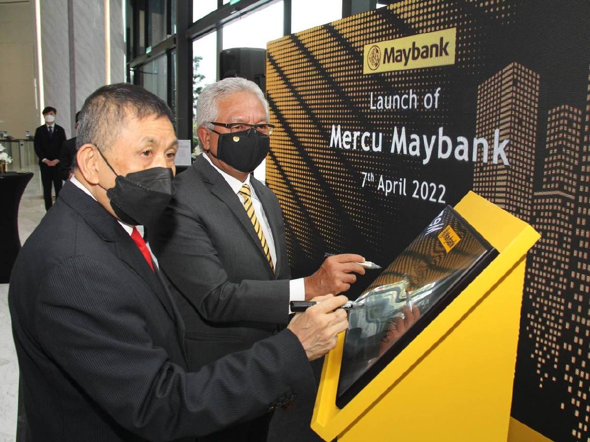 Lim (kiri) dan Zamzamzairani menandatangani plak sebagai tanda perasmian Mercu Maybank.