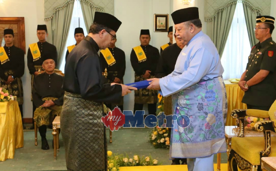 TUANKU Syed Sirajuddin menyerahkan watikah pelantikan Menteri Besar Perlis kepada Azlan di Istana Arau, hari ini. FOTO Amran Hamid 