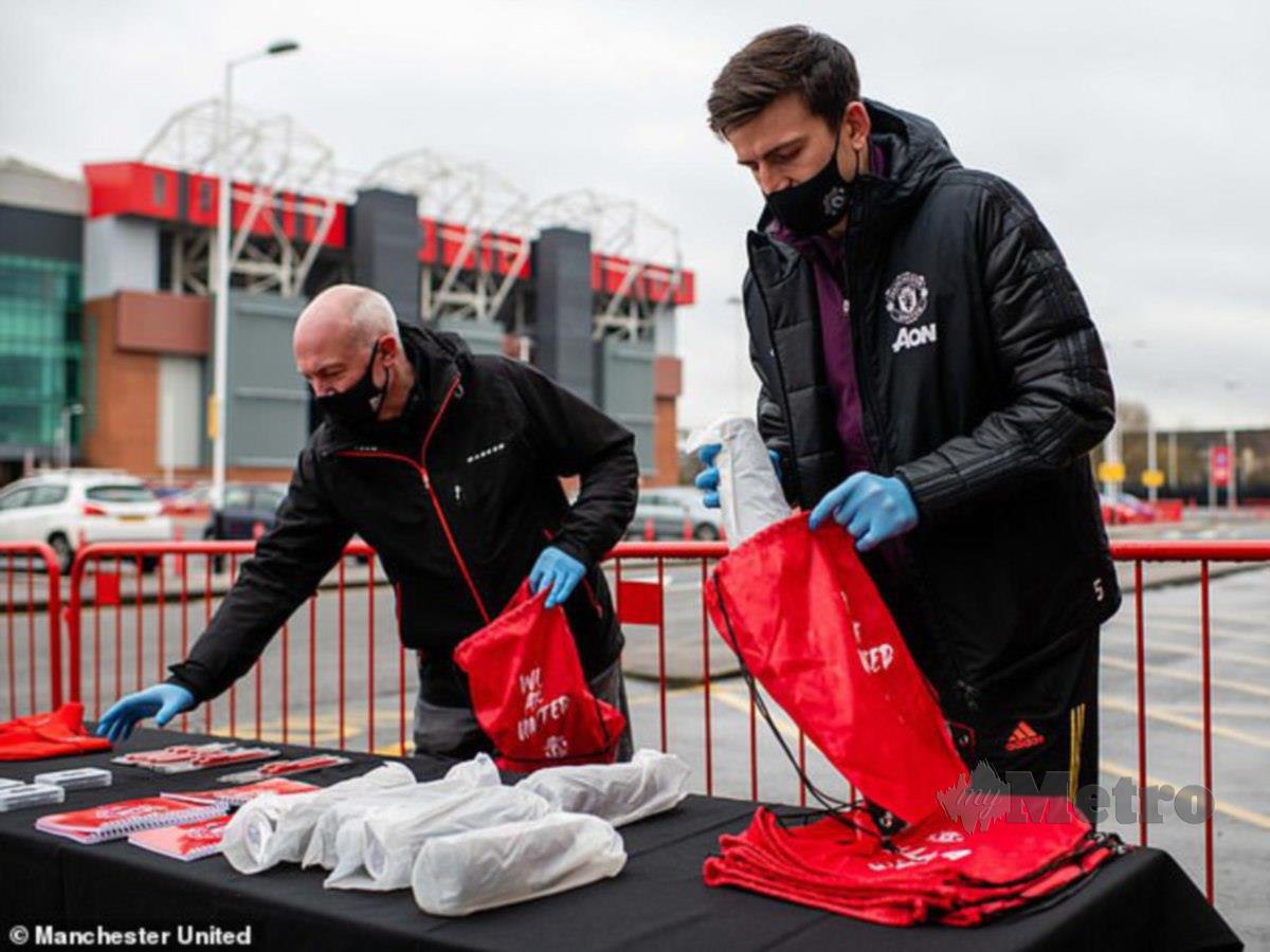 Maguire (kanan) membantu mengagihkan hadiah sempena krismas. FOTO MUFC