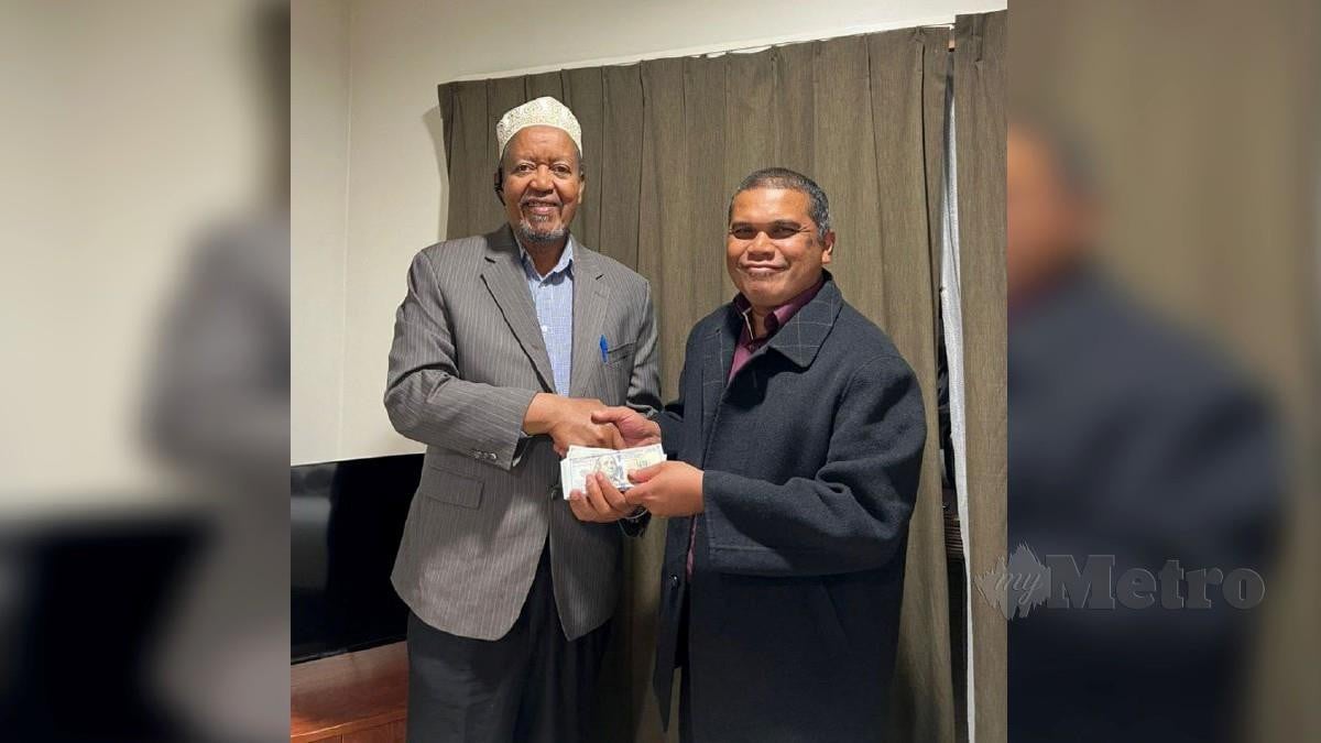 SHIEKH Muridi Amin (kiri) menyalurkan bantuan kepada Zulkifli. FOTO ihsan Muslim Care Malaysia Society