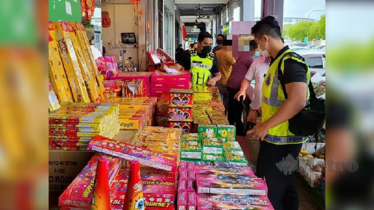 Anggota polis melakukan pemeriksaan terhadap mercun, bunga api yang dijual secara terbuka di kaki lima premis di Jalan Kempas di Kuching, semalam. Foto Melvin Joni 
