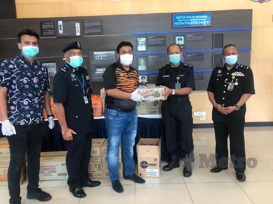 MEGAT (tiga kiri) menyerahkan bantuan makanan kepada Polis  Kontinjen Selangor yang diwakili Timbalan Ketua Polis Selangor, Datuk Arjunaidi Mohamed. FOTO Syazwan Msar