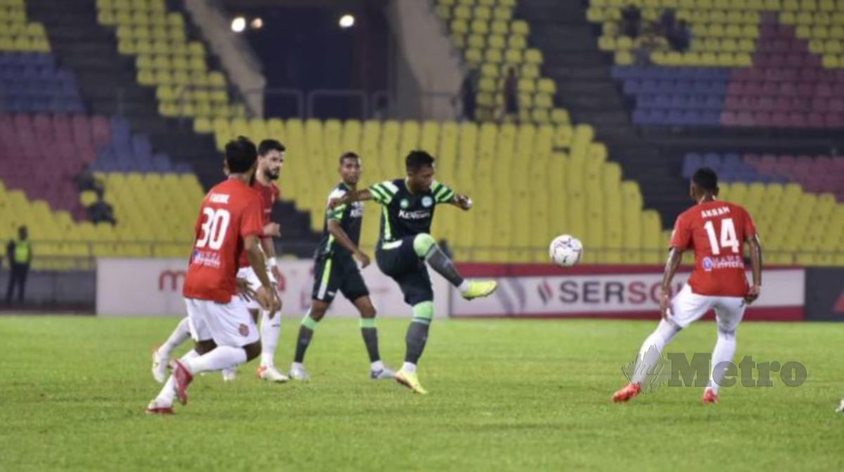 PEMAIN pertahanan Melaka United (MU) Muhammad Fauzan Mohd Fauzi (tengah) mengeluarkan bola dari kawasan bahaya. FOTO NAZRI ABU BAKAR