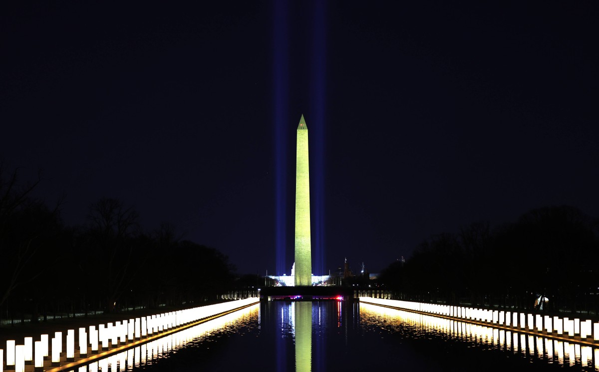LAMPU di tepi kolam Lincoln Memorial dinyalakan selepas Biden dan Harris menghadiri majlis penghormatan ringkas buat korban Covid-19. FOTO AFP.