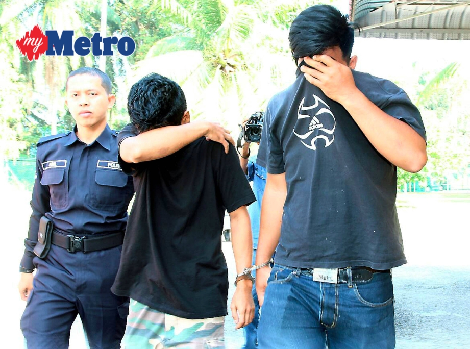 Anggota polis membawa tertuduh, Mohd Afizal (kanan) dan Muhammad Khairi ke Mahkamah Majistret Jawi, Nibong Tebal atas kesalahan memiliki mercun semasa ditahan selepas Pulau Pinang tewas pada Sarawak 1 - 0 di Stadium Batu Kawan, Pulau Pinang pada 11 Februari yang lalu. FOTO Amir Irsyad Omar
