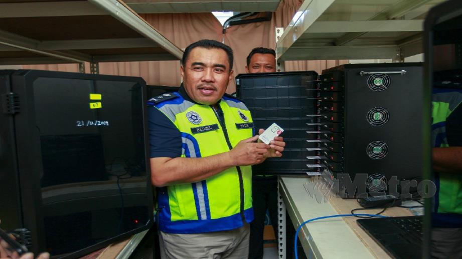 Fadzil menunjukkan mesin Blaster yang digunakan bertujuan mempromosi aktiviti perjudian dalam talian ketika serbuan di sebuah hotel bajet di Puchong hari ini. Foto Asyraf Hamzah 