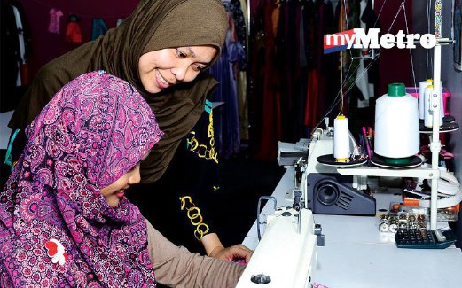 Zinatul (kiri) mendapatkan tunjuk ajar daripada Siti Salmah di Yasalma Online Sewing School.