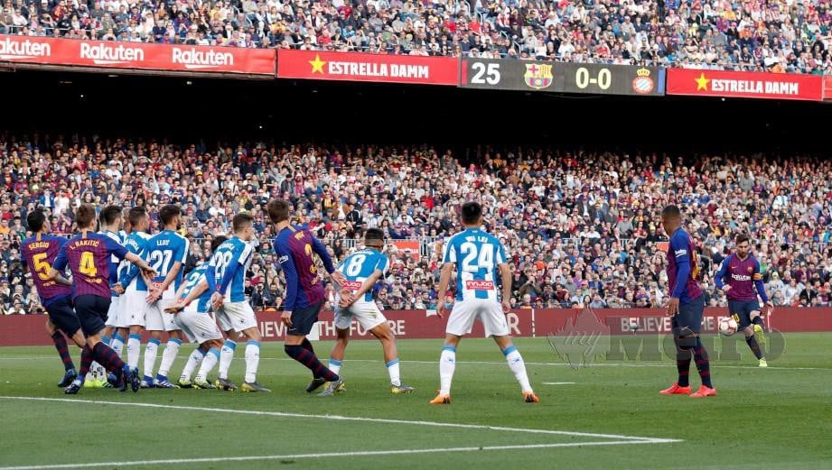 LIONEL Messi (kanan) melakukan sepakan percuma yang menjurus kepada gol pertama di Nou Camp, Sabtu lalu. — FOTO Reuters