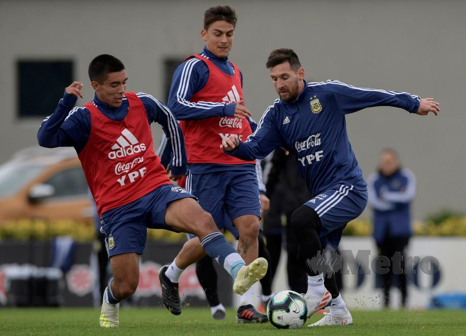 MESSI (kanan) melepasi pemain B-17 Argentina sambil disaksikan Paulo Dybala (tengah) ketika sesi latihan Argentina di Ezeiza, awal pagi tadi. — FOTO AFP