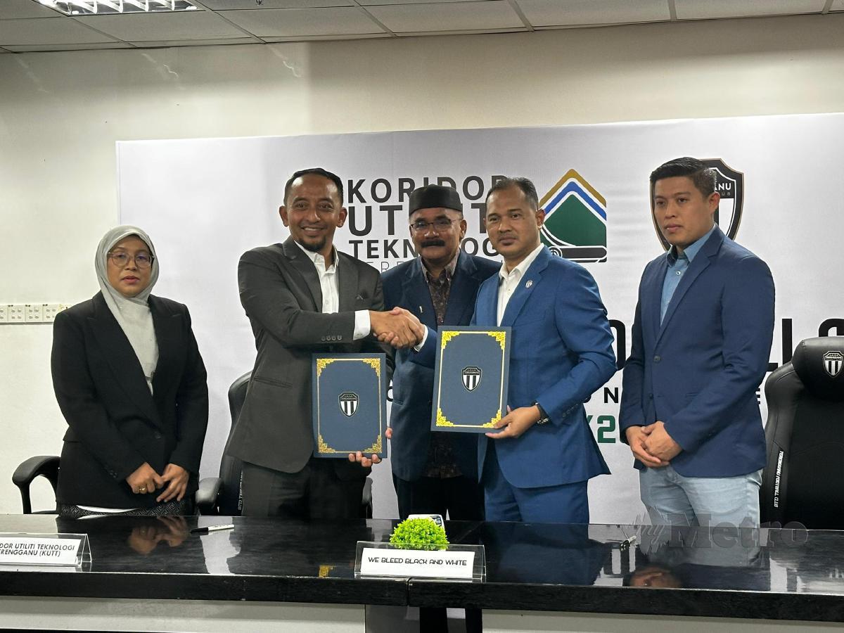 Mohd Sabri (dua kanan) bertukar dokumen perjanjian dengan CEO KUTT, Ahmad Azhan Suhaili@Ismail di Stadium Sultan Mizan Zainal Abidin, Gong Badak. -FOTO Malik Muhamad