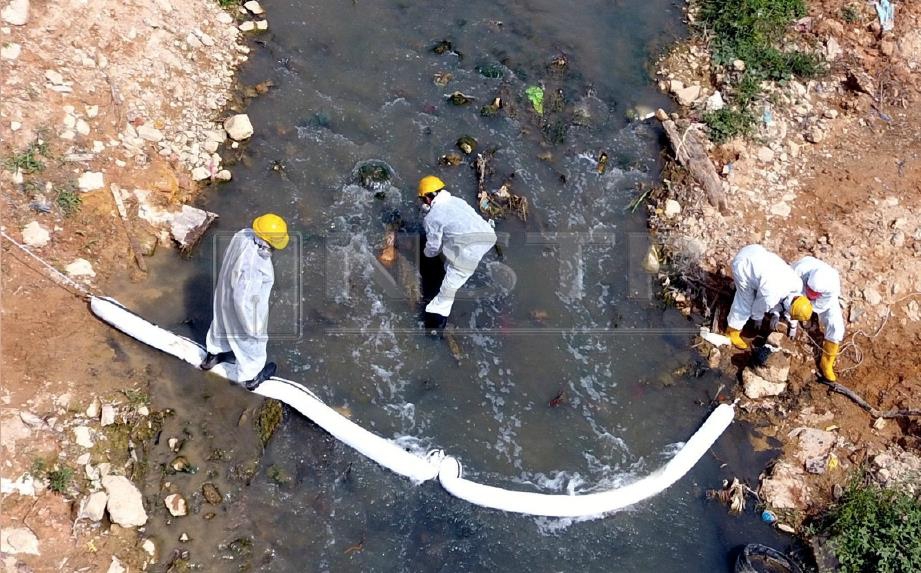 PEKERJA syarikat  pembersihan memulakan kerja pembersihan sisa bahan toksik di Sungai Kim Kim, semalam. FOTO Khairul Ghazali