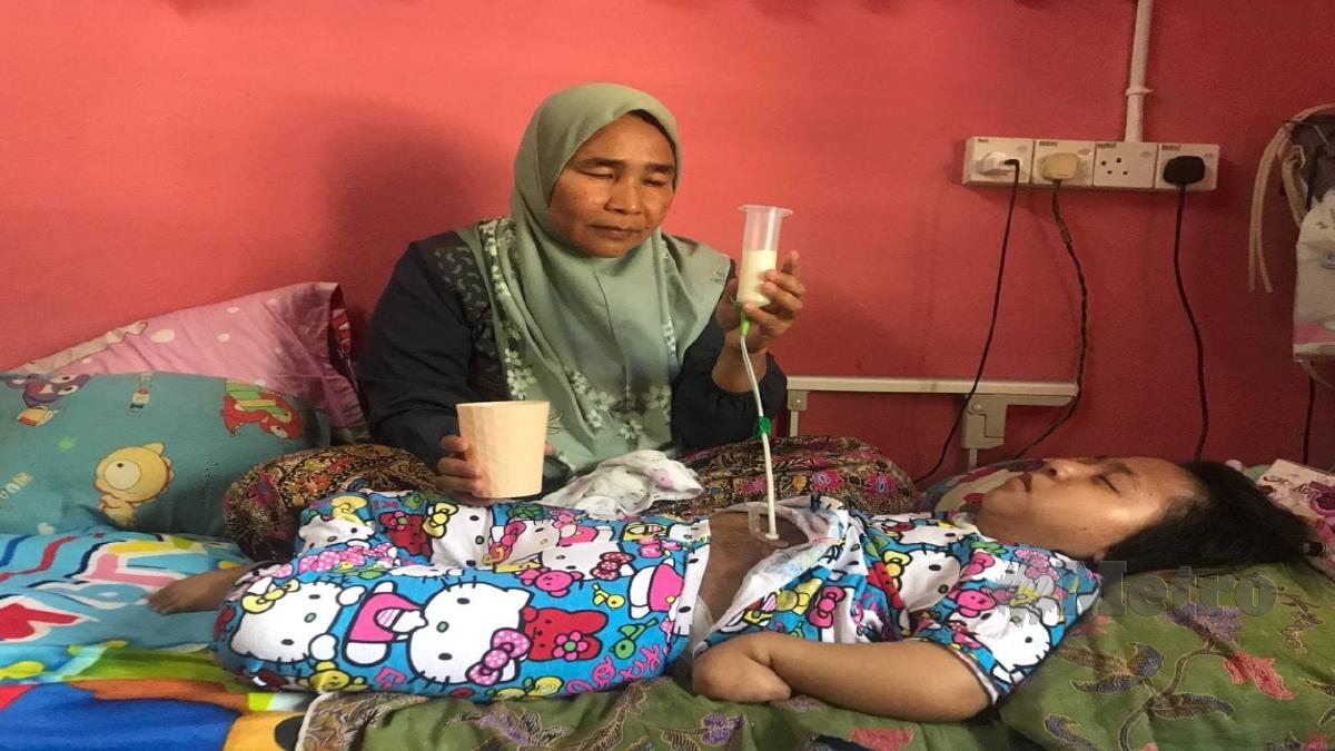 RUSNANI memberi susu kepada Adamia Fitri yang menghidap Cerebral Palsy (CP) dan paru-paru kronik. FOTO Hazira Ahmad Zaidi. 