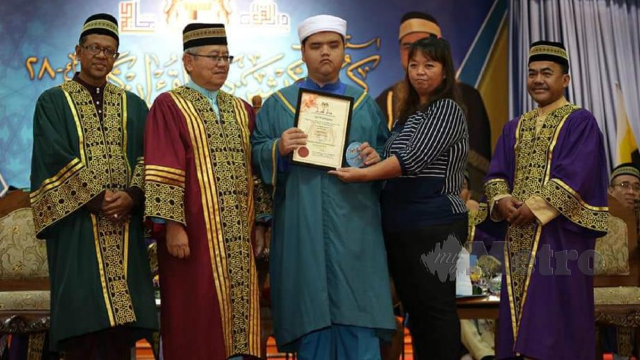 Mike (tiga dari kiri) menerima Sijil Asas Tahfiz dan Sijil Anugerah Khas selepas berjaya menamatkan pengajian di DQ. FOTO Ihsan Pembaca