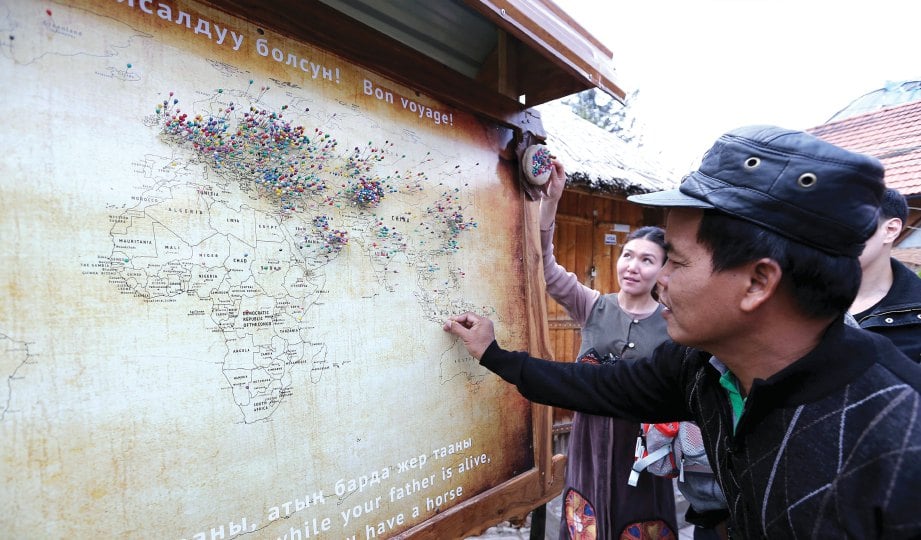 PELANCONG dari Indonesia mencucuk jarum untuk menandakan negara asalnya di Kompleks Ethno Supara.